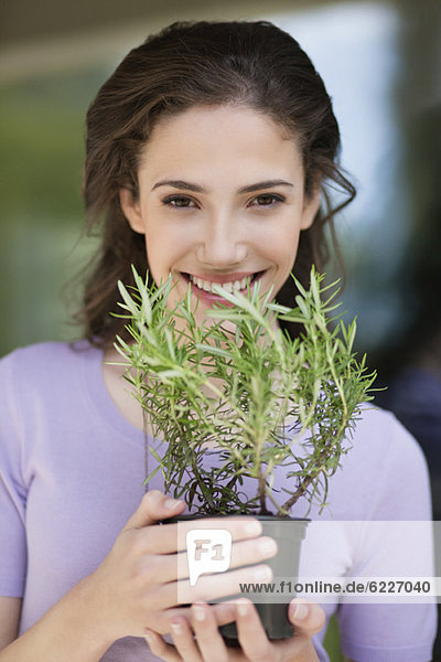 Woman smelling a rosemary plant