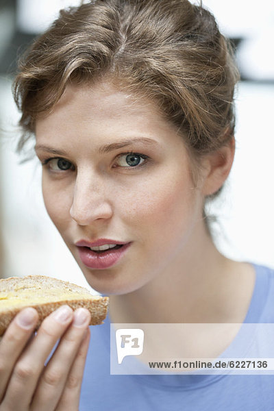 Porträt einer Frau beim Brotessen