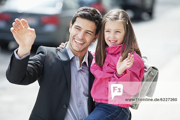 Man and his daughter waving hands