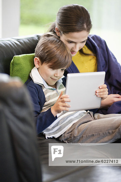 Frau und ihr Sohn betrachten ein digitales Tablett