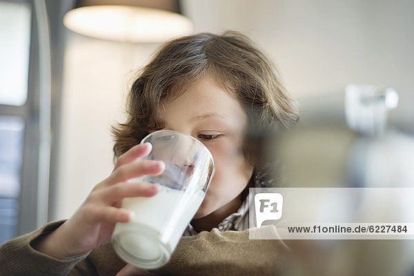 Nahaufnahme eines Jungen  der ein Glas Milch trinkt.