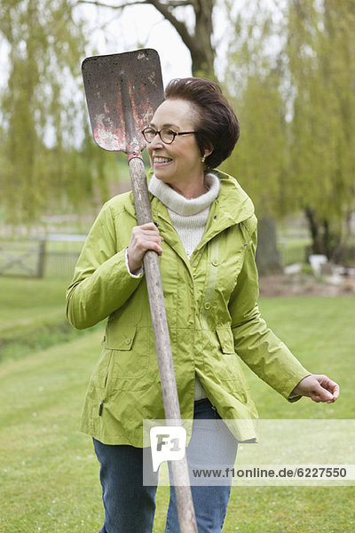 Woman walking with a spade in a park