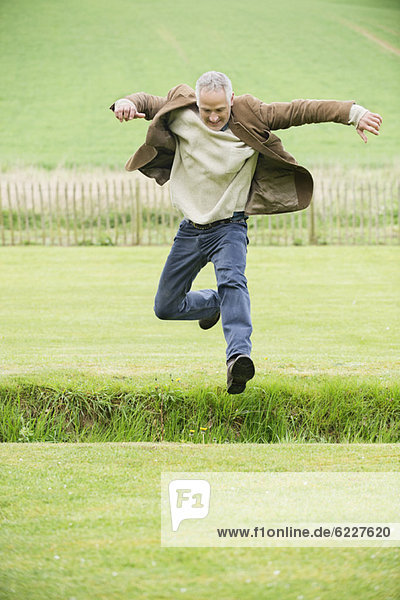 Mann beim Springen auf einem Feld