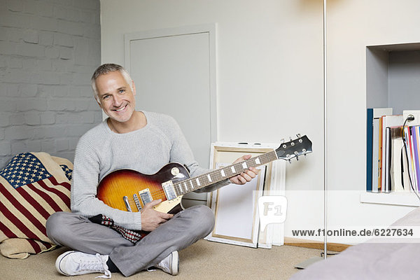 Portrait of a happy man playing a guitar