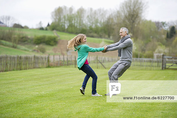 Mann spielt mit seiner Tochter auf einem Feld