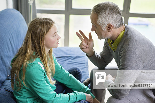 Mann im Gespräch mit seiner Tochter zu Hause