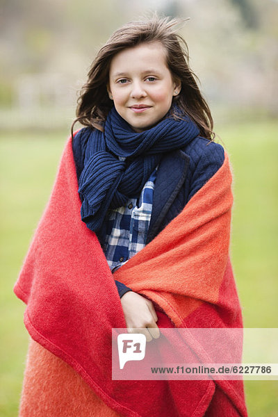 Portrait of a girl wrapped in a blanket and smiling