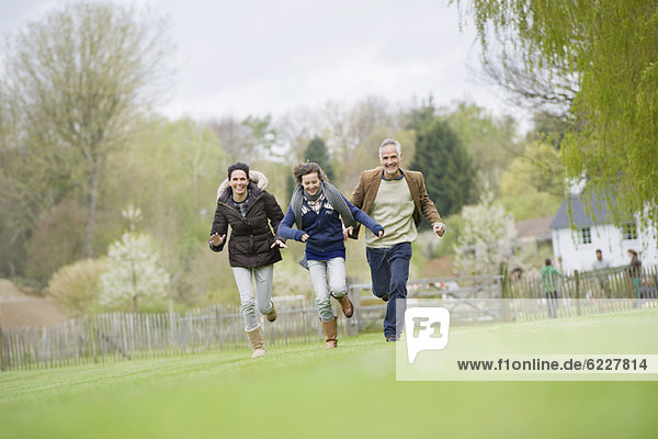 Happy family running in a field