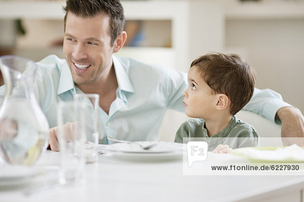 Mann mit seinem Sohn am Esstisch sitzend