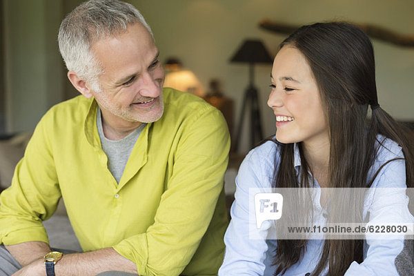 Man and his daughter smiling at home
