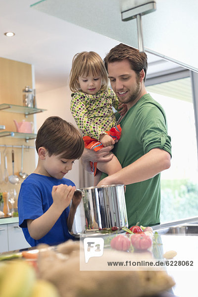 Man with his son and daughter in the kitchen