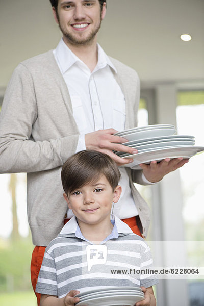 Man and son arranging plates for lunch