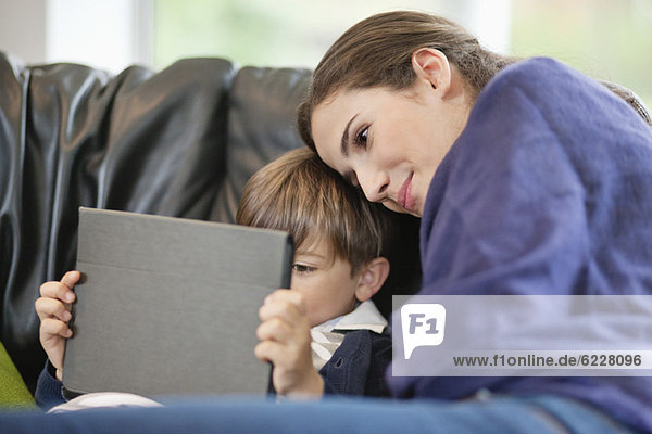Woman looking at her son using a digital tablet