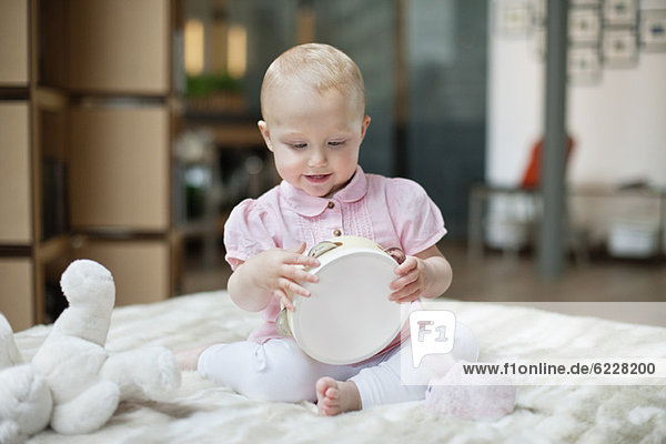 Kleines Mädchen spielt mit einem Tamburin