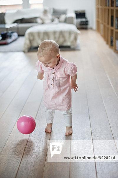 Kleines Mädchen spielt mit einem Ball