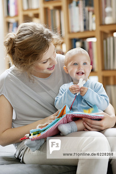 Woman reading a story to her baby from a picture book