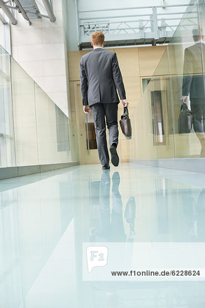 Rear view of a businessman walking in an office corridor