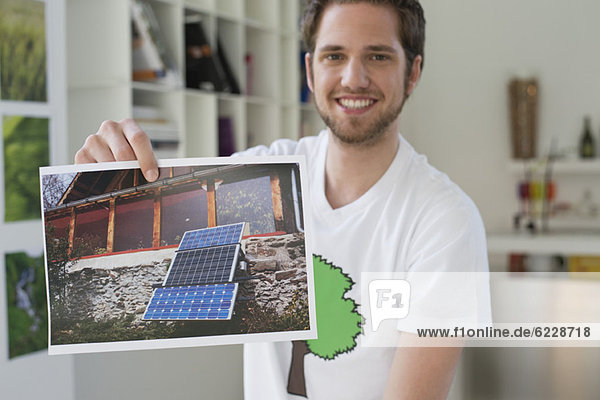 Mann zeigt ein ökologisches Poster von Solarpaneel