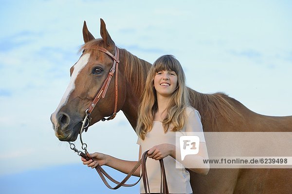 Lächelnde Teenagerin mit Pferd
