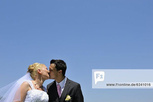 Hochzeit  junges Brautpaar küsst sich
