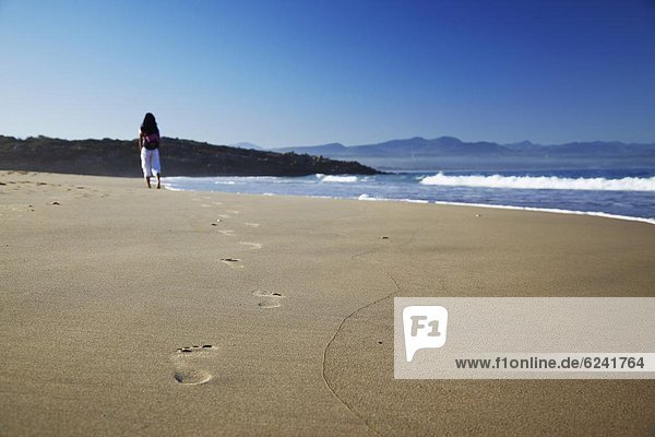 Woman walking on beach  Plettenberg Bay  Western Cape  South Africa  Africa