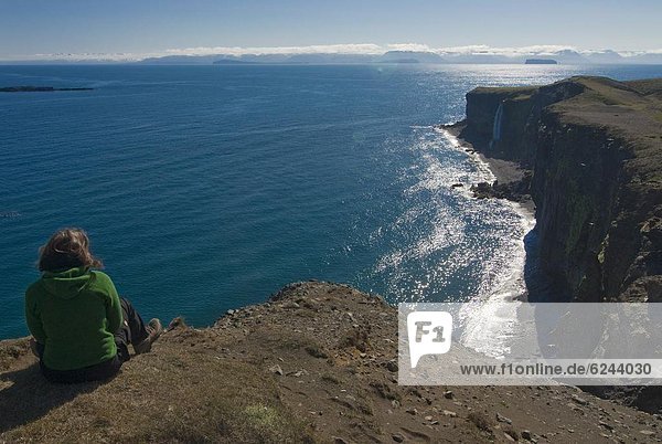 sitzend  Frau  über  Steilküste  Küste  Island  steil