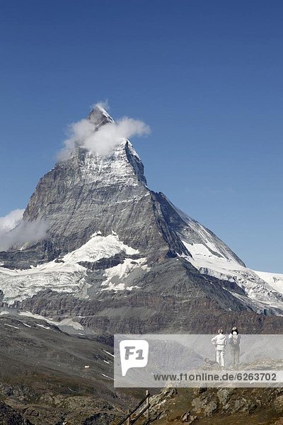 Two hikers in front of the Matterhorn  Gornergrat  Zermatt  Valais  Swiss Alps  Switzerland  Europe