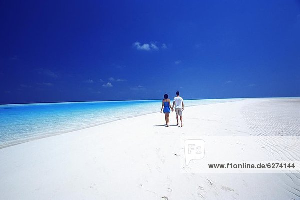 Couple walking on the beach  Maldives  Indian Ocean  Asia