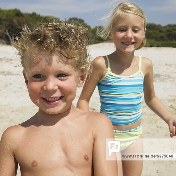 Boy and girl (6-8) on beach