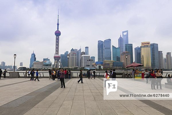 Pedestrians and tourists on the Bund  the futuristic skyline of Pudong across the Huangpu River beyond  Shanghai  China  Asia