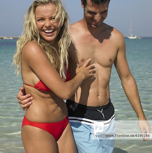 Couple walking on beach  laughing