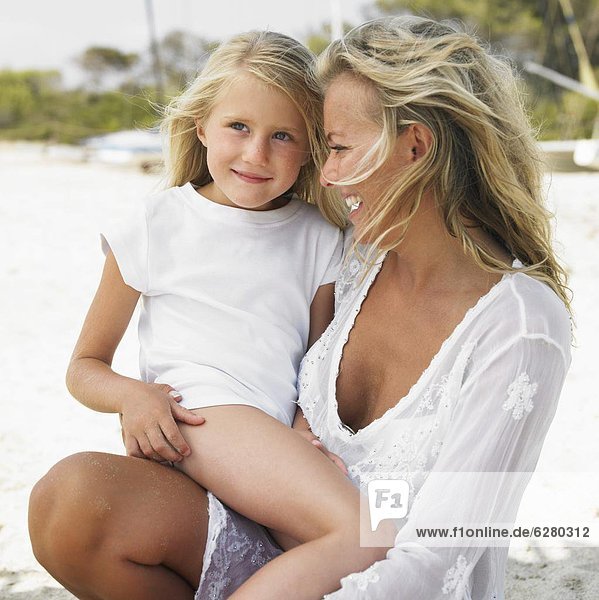 Mother and daughter (6-8) on beach