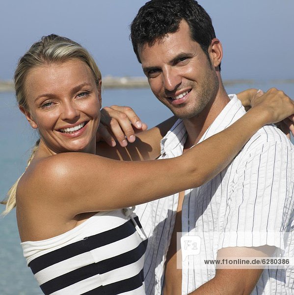 Couple embracing on beach  smiling