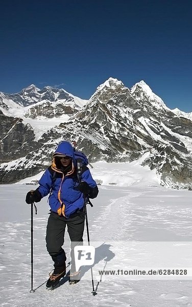 A climber walks towards advanced base camp at 5800 metres on Mera Peak  6420 metres  a popular trekking peak in the Khumbu region  with Mount Everest beyond  Nepal Himalaya  Nepal  Asia