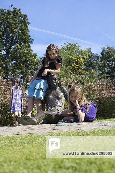 Children playing on statue  Golders Hill Park  bordering on Hampstead Heath  London  England  United Kingdom  Europe