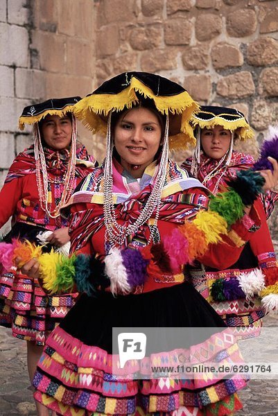 Portrait of three local Peruvian girls in traditional dance dress  looking at the camera  Cuzco  Peru  South America
