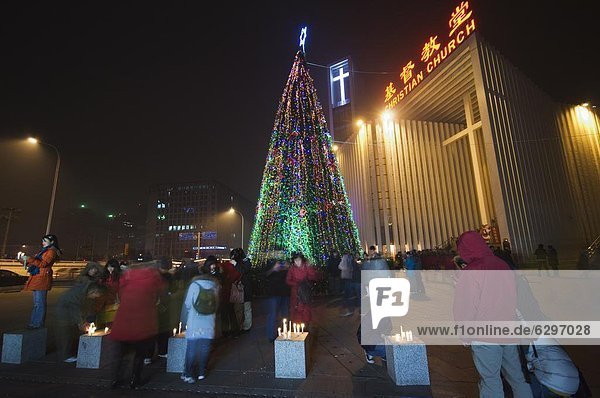 Night time illuminations of a Christmas tree and decorations at a Christian church celebrating in Beijing  China  Asia