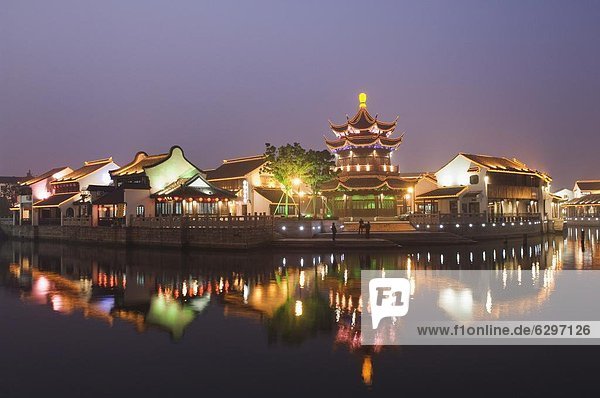 Traditional old riverside houses and pagoda illuminated at night in Shantang water town  Suzhou  Jiangsu Province  China  Asia