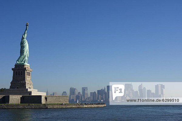 Statue of Liberty  Liberty Island and Manhattan skyline beyond  New York City  New York  United States of America  North America