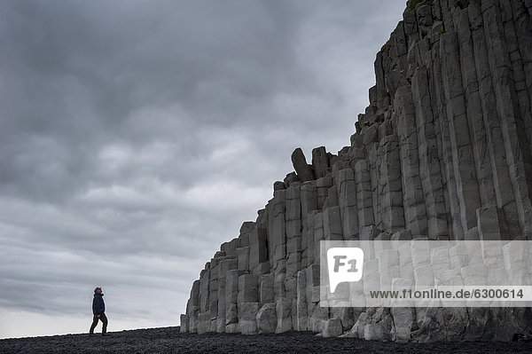 Man looking at basalt columns Reynisfjara beach a black beach near Vik Ì M_rdal southern coast Iceland Europe