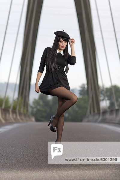 Young woman in a short black dress posing on the bridge in Root  Lucerne  Switzerland  Europe
