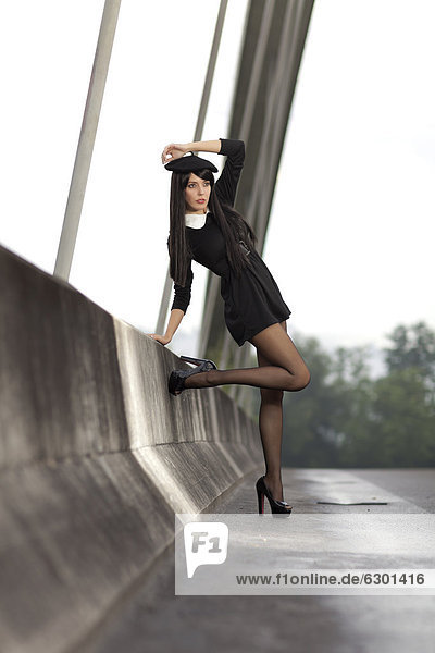 Young woman wearing a short black dress posing on the bridge in Root  canton of Lucerne  Switzerland  Europe