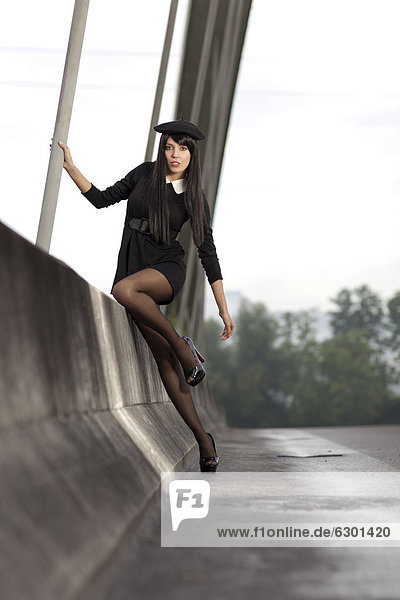 Young woman wearing a short black dress posing on the bridge in Root  canton of Lucerne  Switzerland  Europe