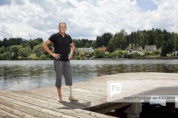 Man with a prosthetic leg standing on a jetty