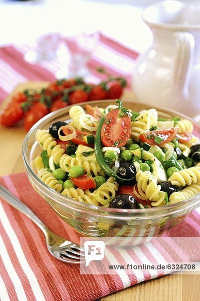 Nudelsalat mit grünen Bohnen  Erbsen  Tomaten  Oliven und Frühlingszwiebeln
