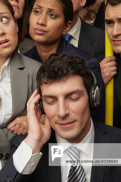Businesswoman wearing headphones on subway train