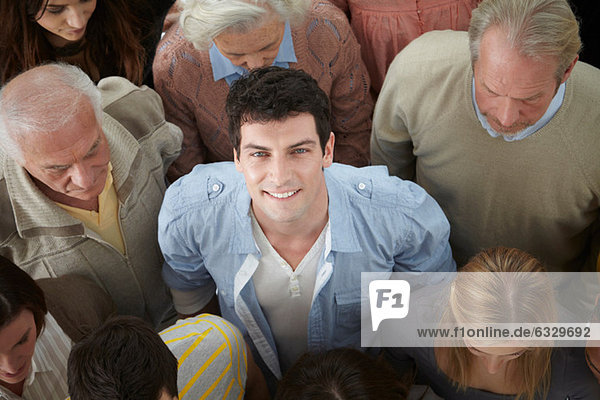 Porträt eines Mannes  der in einer Personengruppe auf die Kamera schaut  hoher Winkel