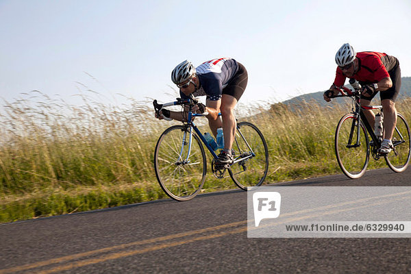 Two cyclists or road  racing downhill