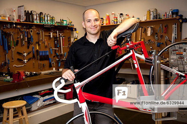 Man with bicycle in repair shop
