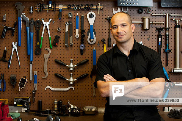 Man in front of wall of tools in workshop